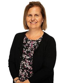 Headshot photo of Kim Bennett standing in front of a white background.